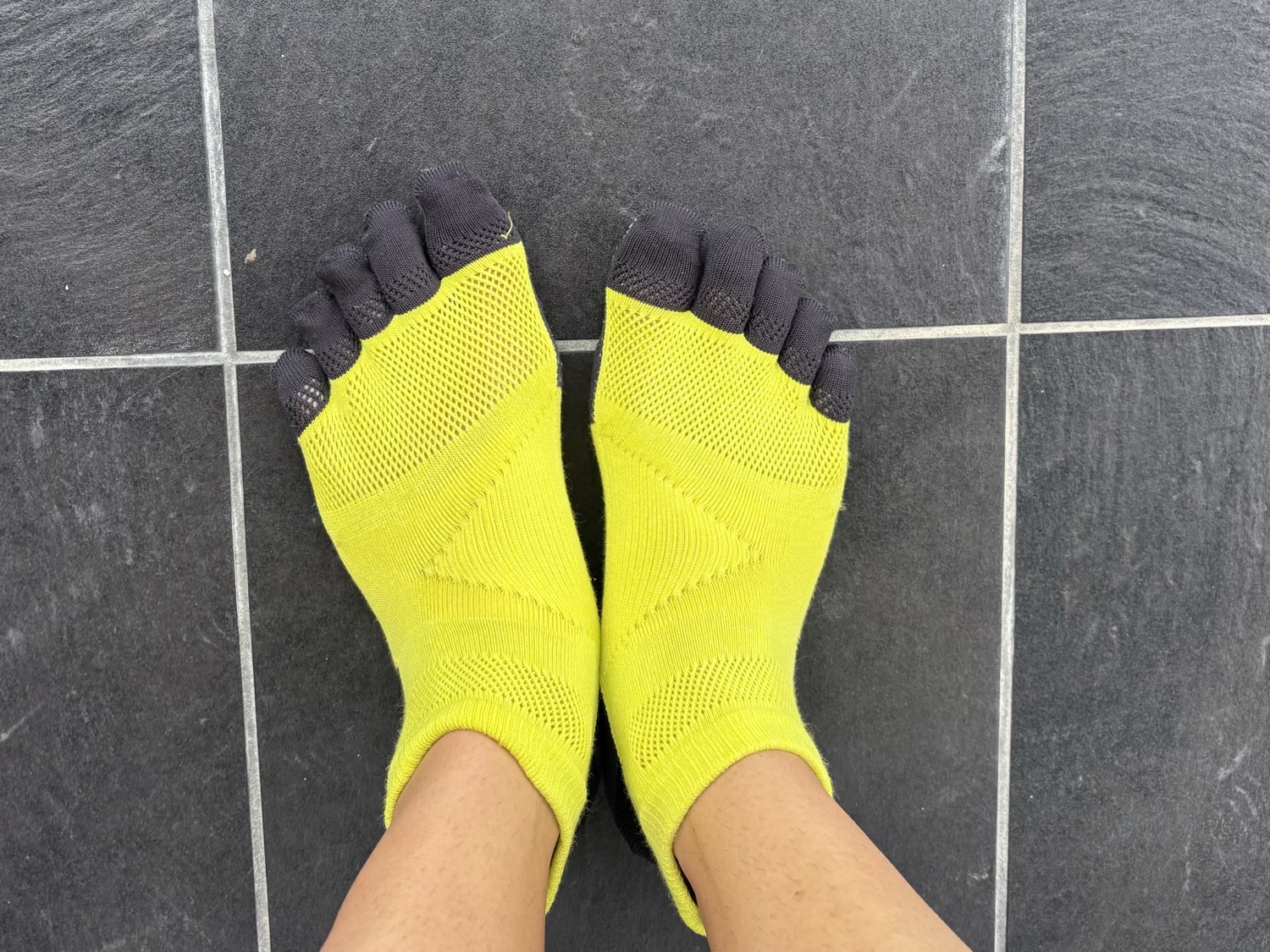 TABIO SPORTS レーシングラン・プロ五本指を実際に履いた状態の足元。蛍光イエロー本体につま先部分が黒のデザイン。